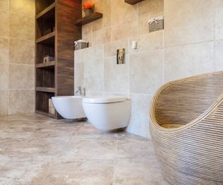 Beige and bright bathroom with wicker chair
